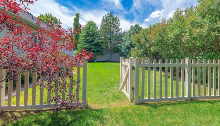 A functional fence gate providing access to a well-maintained backyard, surrounded by a wooden fence in Long Beach